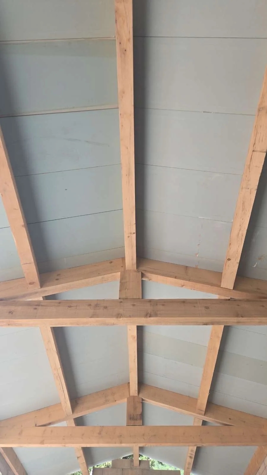 Vue intérieure des poutres en bois d’une charpente sous les panneaux de toiture